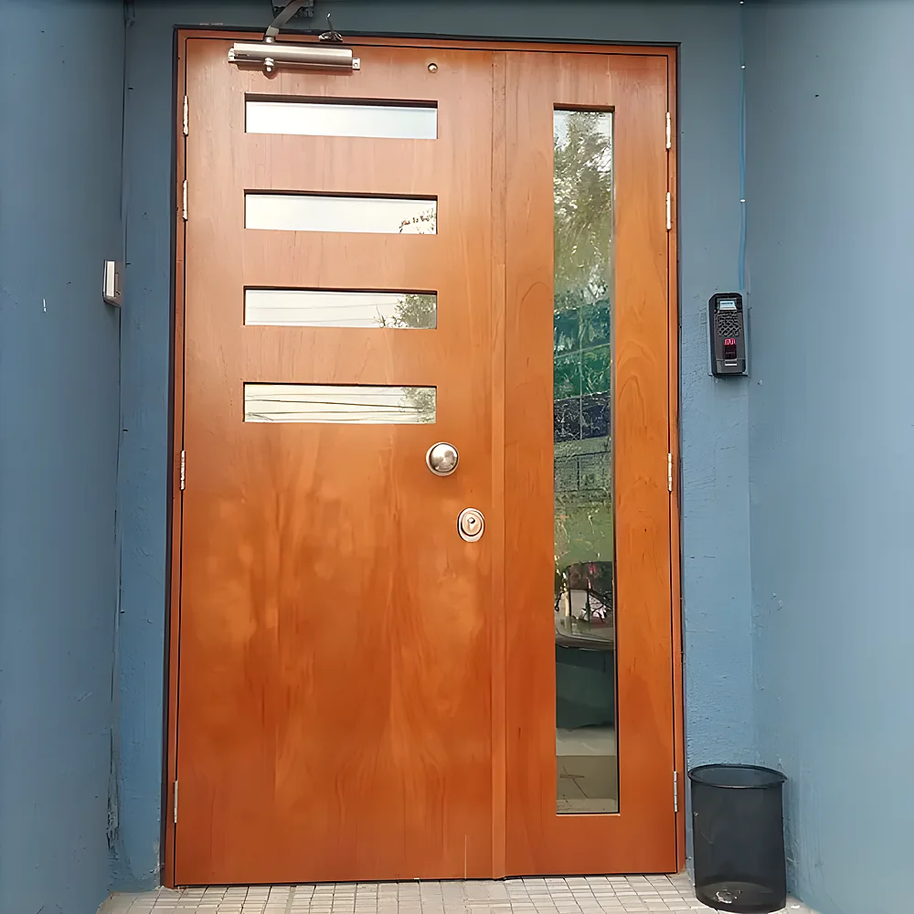 Puerta blindada modelo Asunción, enchapada lisa con ventanillas de vidrio de seguridad y paño lateral