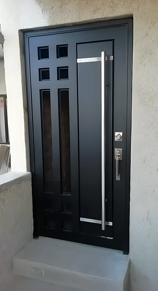 Puerta blindada modelo Dakar, negra con ventanillas cuadradas y tirador largo