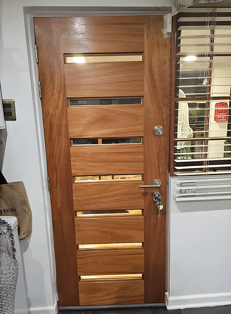 Puerta blindada modelo Damasco, moderna de cantería en bajo relieve con ventanillas