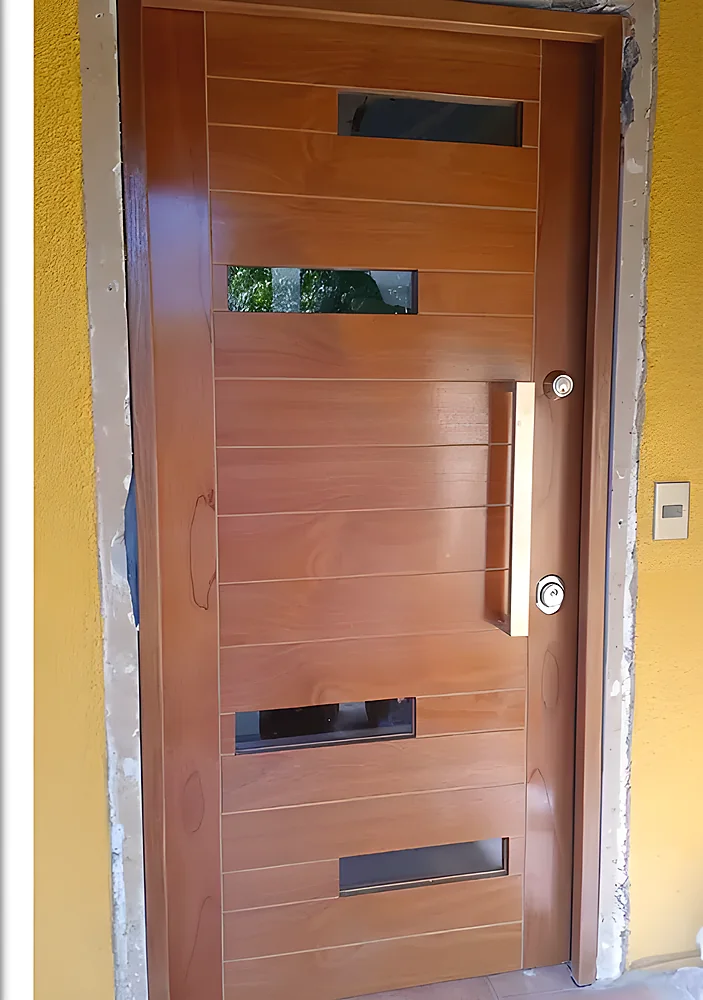 Puerta blindada modelo Quito, moderna con insertos negros y tirador largo