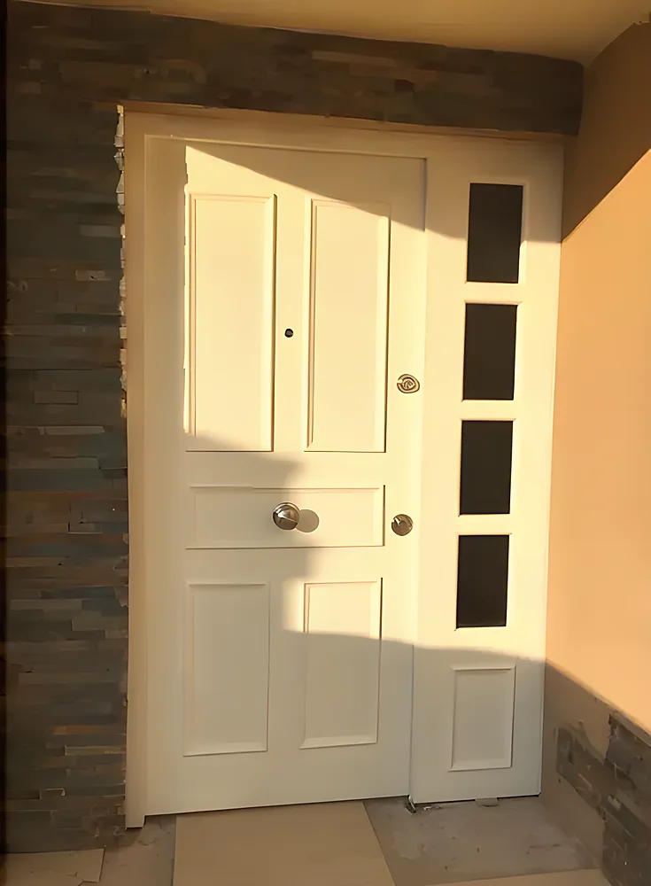 Puerta blindada modelo Washington, blanca con ventanillas verticales y moldura decorativa por ambas caras